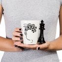Kubek Szachisty, biały kubeczek ze wzorem szachownicy i uchem w kształcie czarnej figury szachowej Król, dla fana gry w szachy.
